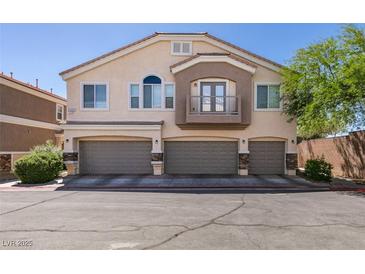 Inviting townhome featuring a three-car garage, balcony, and desert landscaping at 5509 Ante Up Ct # 102, Las Vegas, NV 89122