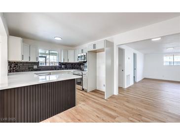 Bright eat-in kitchen with shaker cabinets, dark tile backsplash, quartz counters and stainless appliances at 6308 Lawton Ave, Las Vegas, NV 89107