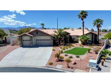 Charming single-story home with a three car garage, desert landscaping and palm trees under a blue sky at 7540 Crystal Cave Dr, Las Vegas, NV 89117
