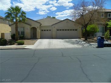 Charming single-story home with a two-car garage, desert landscaping, and a palm tree at 981 Buffalo River Ave, Henderson, NV 89002