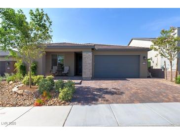 Beautiful single-story home with a two-car garage and a well-manicured, low-maintenance front yard at 10049 Cardinal Knoll Ave, Las Vegas, NV 89143