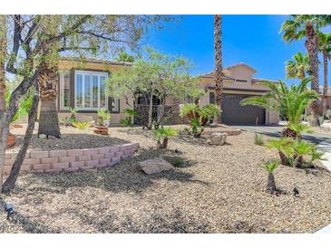 Charming single-story home featuring a desert landscaped front yard with stone accents and mature palm trees at 10237 Andante Ct, Las Vegas, NV 89135