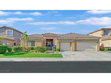Attractive single-story home boasts a three-car garage and well-maintained landscaping at 2410 Sunburst View St, Henderson, NV 89052
