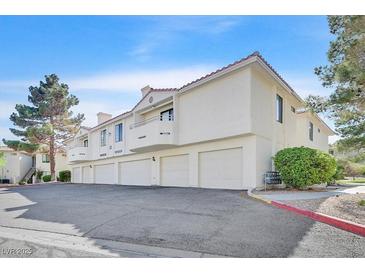 Low angle shot showing exterior of condo building with multiple garages, balconies, and red clay roof at 2633 S Durango Dr # 204, Las Vegas, NV 89117