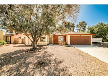 Charming single-story home with a mature tree in the front yard and a two-car garage at 3596 Bronco Rd, Las Vegas, NV 89103