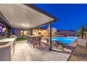Outdoor living area with a covered kitchen, dining, lounge, and stunning pool at 461 Highview Ridge Ave, Las Vegas, NV 89138
