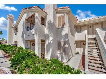 Condo exterior features well-maintained landscaping, stairways to upper units, and a neutral color scheme at 605 Devonhall St # 202, Las Vegas, NV 89145