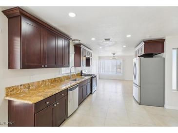 Spacious kitchen features granite countertops, stainless appliances, and dark wood cabinets at 7139 Mountain Moss Dr, Las Vegas, NV 89147