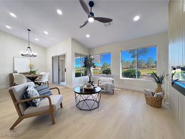 Bright living room with vaulted ceilings, modern furnishings, and large windows offering picturesque views at 9369 Villa Ridge Dr, Las Vegas, NV 89134