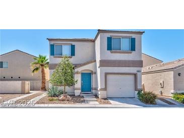 Charming two-story home featuring a stucco facade, attached garage, blue shutters, and manicured landscaping at 9979 Keephills St, Las Vegas, NV 89183