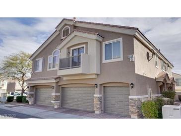 Attractive townhome featuring a three-car garage and desert landscaping at 9994 Government Point Way # 101, Las Vegas, NV 89183