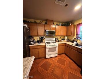 Traditional kitchen featuring wood cabinets and gas range at 1001 Declaration Dr, Las Vegas, NV 89110