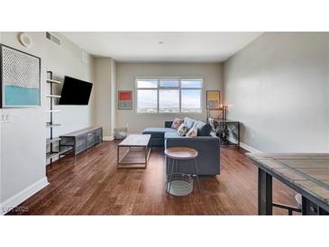 Inviting living room featuring hardwood floors, comfortable seating, and a large window with city views at 150 Las Vegas Blvd # 1118, Las Vegas, NV 89101