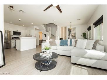 Bright living room featuring modern decor, sleek floors and an open floor plan to the kitchen at 10010 Aspen Rose St # 102, Las Vegas, NV 89183