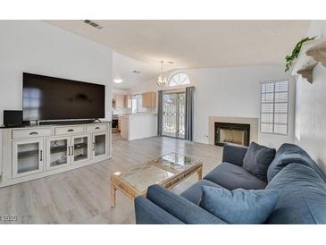 Bright living room featuring a fireplace, TV console, and sliding glass doors to the backyard at 1356 Pleasant Brook St, Las Vegas, NV 89142