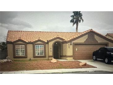 Charming single-story home featuring a tile roof, two bay windows, a welcoming entrance, and a convenient two-car garage at 5020 Wildroot Rd, Las Vegas, NV 89130