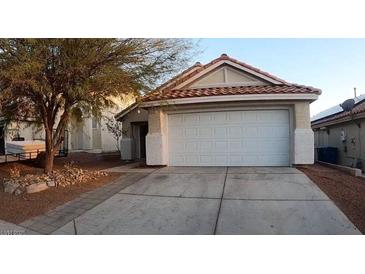 Charming single-story home featuring a two-car garage, desert landscaping and a red tile roof at 6337 Canyon Vista Ct, Las Vegas, NV 89156