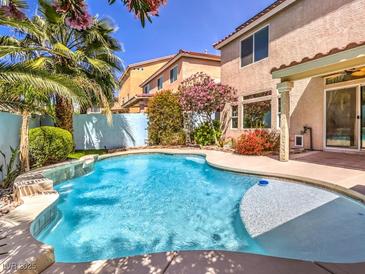 Sparkling pool with lush landscaping and beautiful views in a serene backyard setting at 6779 Goose Watch Ct, Las Vegas, NV 89139