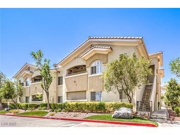 Charming condo building featuring a tan facade, well-maintained landscaping, and convenient stair access at 10109 Jacob Pl # 203, Las Vegas, NV 89144