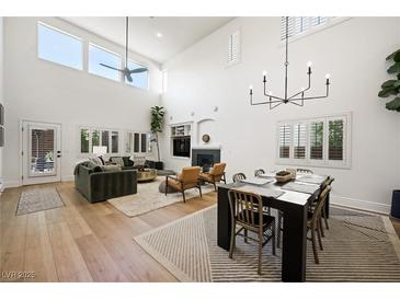 Bright and airy living space with high ceilings, modern chandelier, and comfortable seating arrangement at 11340 Espadrille Ct, Las Vegas, NV 89138
