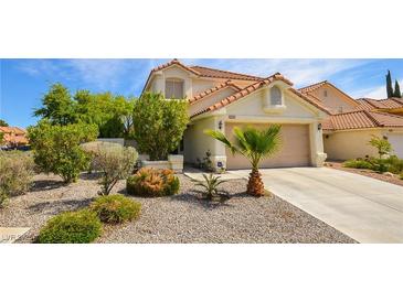 Inviting single-Gathering home featuring desert landscaping, a two-car garage and a traditional roof at 9408 Amber Valley Ln, Las Vegas, NV 89134