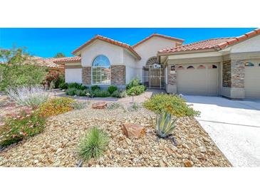 Charming single-story home featuring desert landscaping, stone accents, and a secure gated front entry at 1432 Castle Crest Dr, Las Vegas, NV 89117