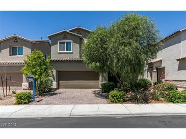 Inviting two-story home features a well-maintained front yard and a brick-paved driveway leading to a two-car garage at 4633 Fragrant St, North Las Vegas, NV 89031