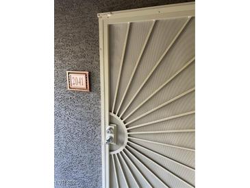 Apartment 2041 front door with a decorative security screen and modern lockset at 5055 W Hacienda Ave # 2041, Las Vegas, NV 89118