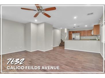 A bright and airy living room with wood-look tile flooring and a ceiling fan at 7632 Calico Fields St, Las Vegas, NV 89149