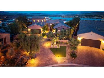 Stunning exterior view of a luxury home with brick driveway, professional landscaping, and lake view at 8 Laricola Ct, Henderson, NV 89011