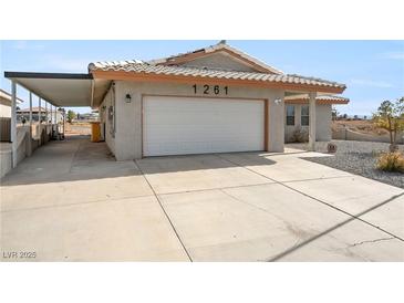 Home with a two-car garage and large driveway at 1261 S Comstock St, Pahrump, NV 89048