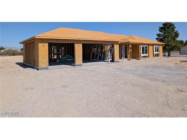 Unfinished home with plywood exterior and two-car garage at 2561 Red Rock Dr, Pahrump, NV 89048