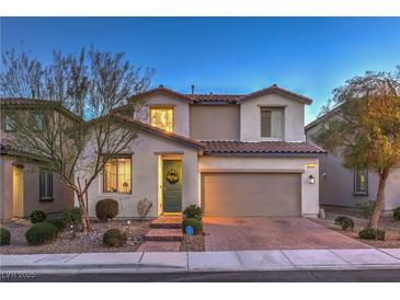 Charming two-story home with a well-maintained front yard, beautiful plants, and a two-car garage at dusk at 3213 Molinos Dr, Las Vegas, NV 89141