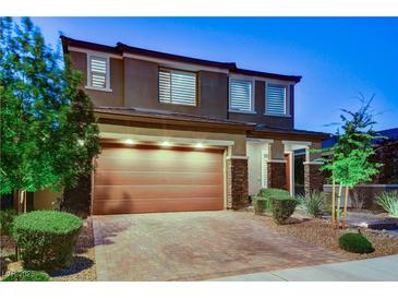 Charming two-story home showcasing a well-manicured front yard and a two-car garage with brick-paved driveway at 361 Cooper Hawk Ct, Las Vegas, NV 89138