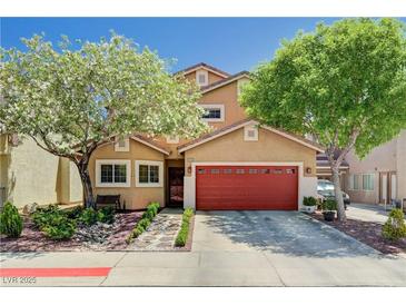 Charming two-story home boasts a vibrant red garage door and mature trees in the landscaped front yard at 9370 Corkfish St, Las Vegas, NV 89178