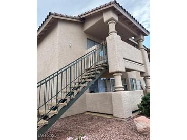 Beige apartment building with stairs leading to a balcony; natural light and modern architecture at 1320 Driscoll Dr # 202, Las Vegas, NV 89128
