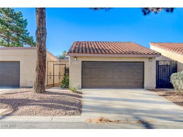 Charming single-story home featuring a brown garage door and a well-maintained, neutral-toned exterior at 1850 Camino Verde Ln, Las Vegas, NV 89119