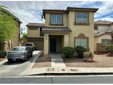 Two-story home with tan stucco exterior, tile roof, covered porch, and landscaped front yard at 4858 Longshot Dr, Las Vegas, NV 89122
