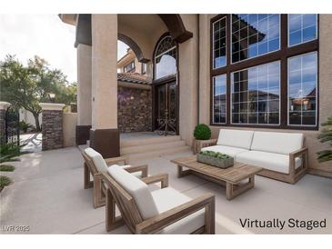 Inviting front porch featuring an outdoor seating area and a view of the home's grand entrance at 5210 Villa Dante Ave, Las Vegas, NV 89141