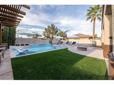 This backyard has a crystal blue pool, a fire pit and a lounge area perfect for entertaining at 5210 Villa Dante Ave, Las Vegas, NV 89141
