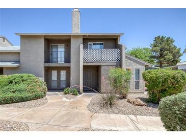 Condo exterior featuring stucco walls, chimney, small balcony, and desert landscaping at 526 Sellers Pl, Henderson, NV 89011