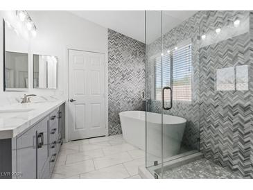 Modern bathroom featuring a soaking tub, glass shower, double vanity, and stylish tile accents at 600 Beresford Ave, Las Vegas, NV 89123