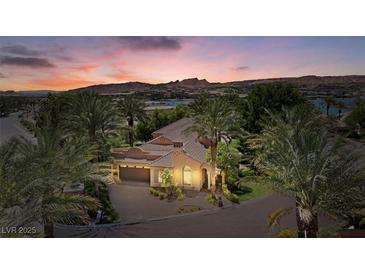 Stunning exterior view of a desert home with lush palm trees and a beautiful sunset sky at 1 Via Mira Monte, Henderson, NV 89011
