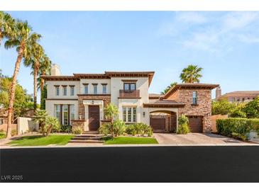Stunning two-story home showcasing lush landscaping and an attached garage, creating a welcoming curb appeal at 10301 Orkiney Dr, Las Vegas, NV 89144