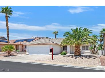 Charming single-story home featuring mature palm trees, a two-car garage, and low maintenance desert landscaping at 130 Park Ridge Ln, Henderson, NV 89002