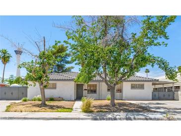 Charming single-story home featuring stucco walls, mature trees and gated access at 1704 S 8Th St, Las Vegas, NV 89104