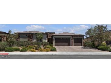 Beautiful single-story home showcasing a two-car garage, a stone facade, and professionally landscaped front yard at 7072 Arabian Ridge St, Las Vegas, NV 89131