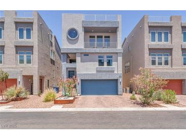 Modern, three-story home features a blue garage door and stylish architectural details at 8076 Haywood Estate Ave, Las Vegas, NV 89113