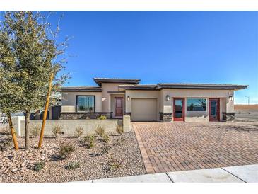 Charming single-story home with a brick driveway and desert landscaping at 1044 Forest Falcon Dr, Henderson, NV 89011