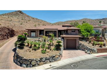 Stunning single-story home nestled in the hills with desert landscaping and an attached garage at 205 Red Rock Rd, Boulder City, NV 89005